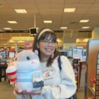 Female student standing in a store holding stuffed animal